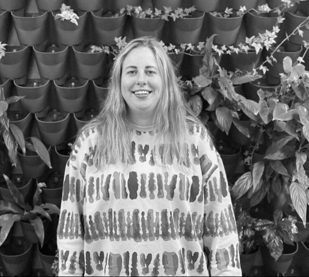 India Gumbley in front of plant wall