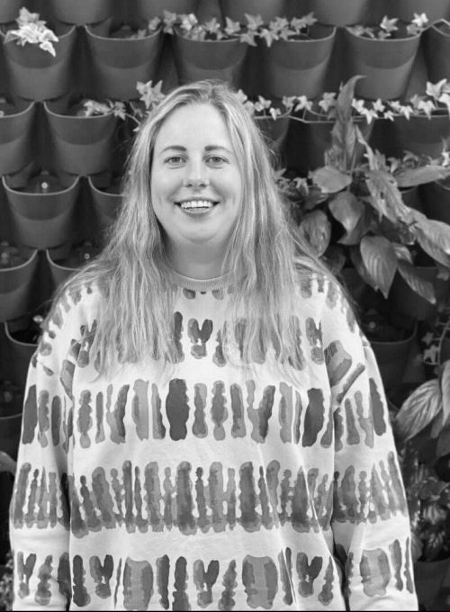 India Gumbley in front of plant wall