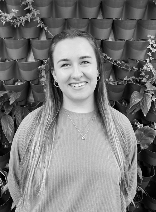 Charlotte stood in front of plant wall