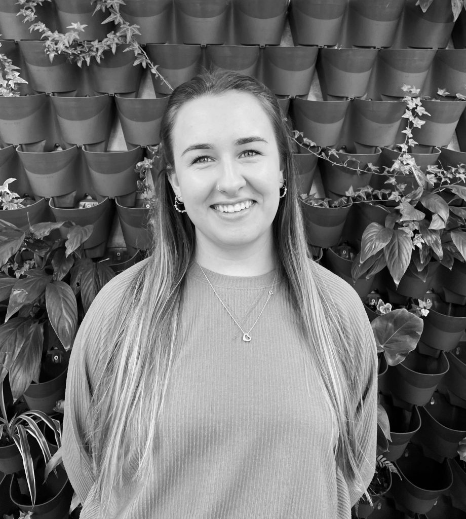 Charlotte stood in front of plant wall