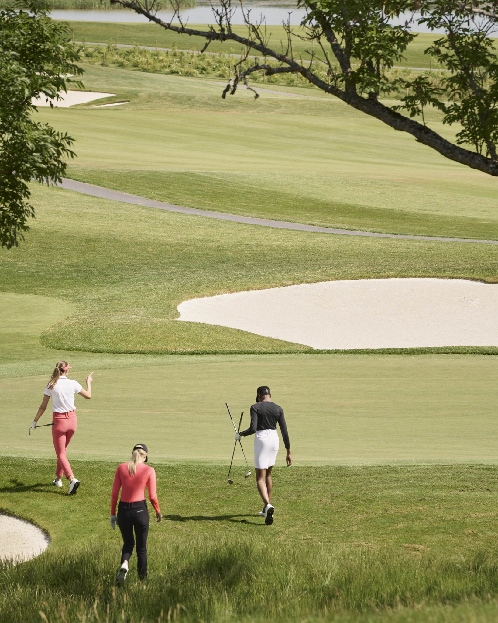 Three women walking onto a golfing green