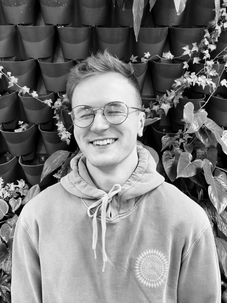 Justin stood in front of plant wall
